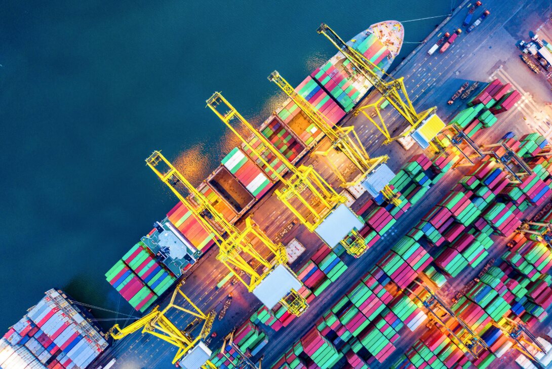 Aerial view of container ships and cranes at a busy port